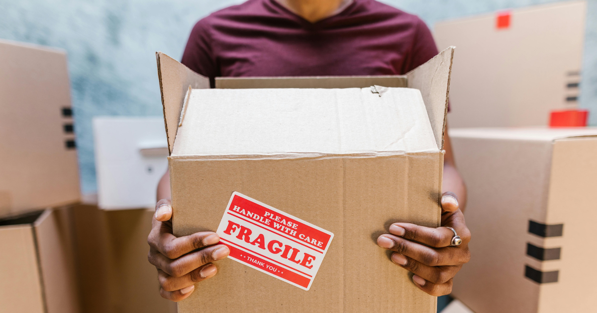 Person carrying a moving box during a move at a multifamily community